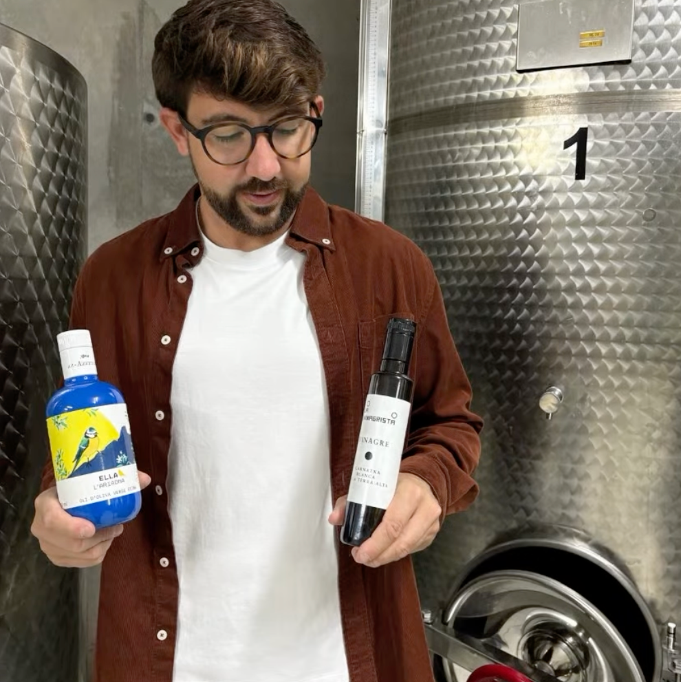 Abel holds two bottles of his olive oil